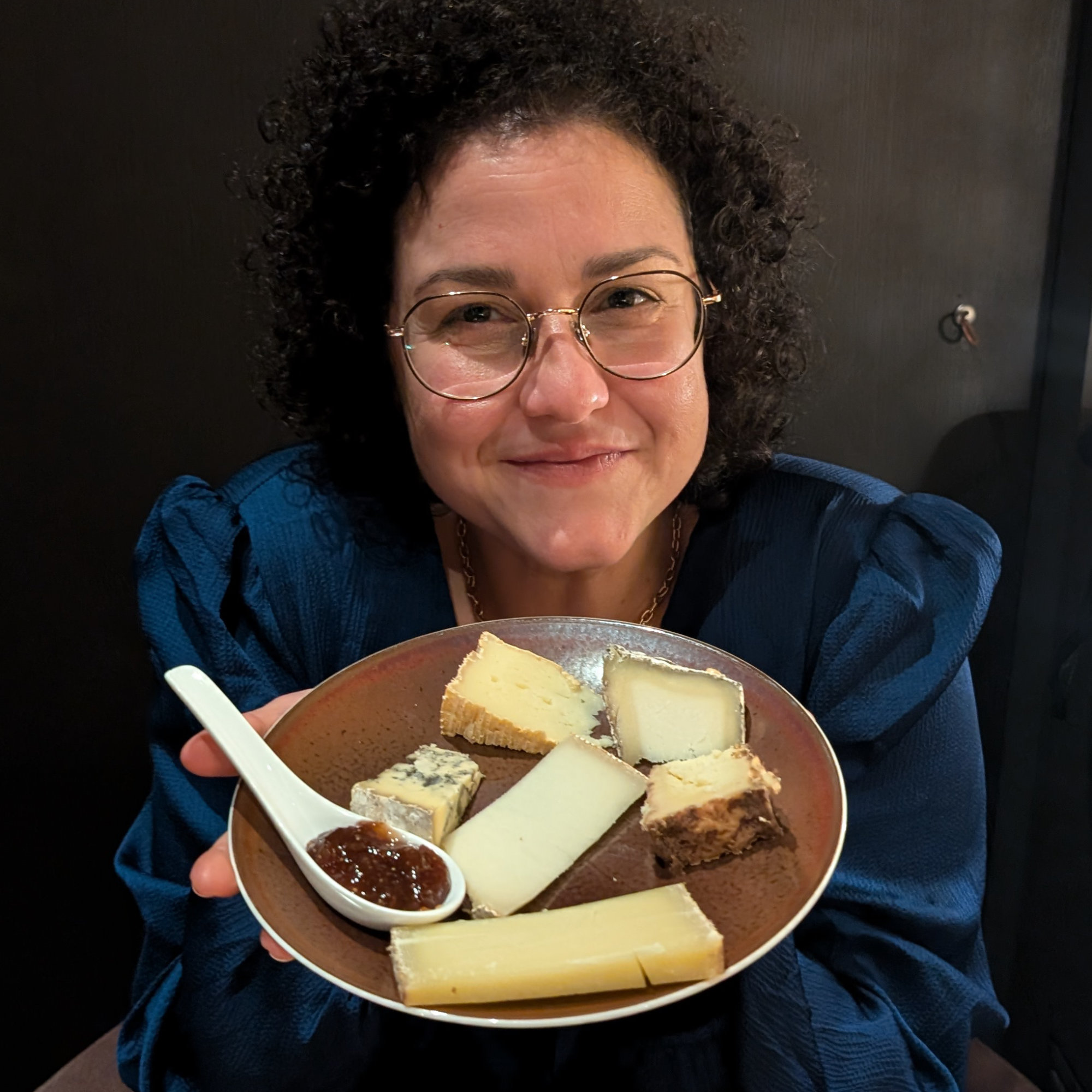 Monica Herrera avec un assiette de fromages dans ces mains