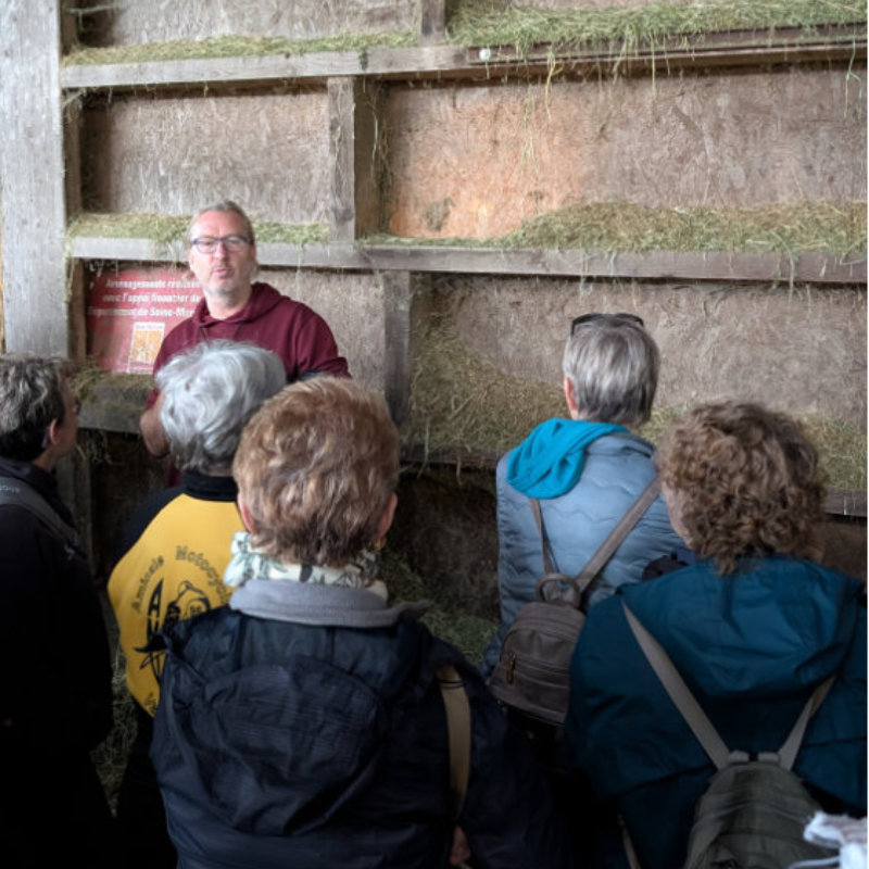 l'animateur montre son séchoir à foin aux visiteurs de la ferme dans un food tour